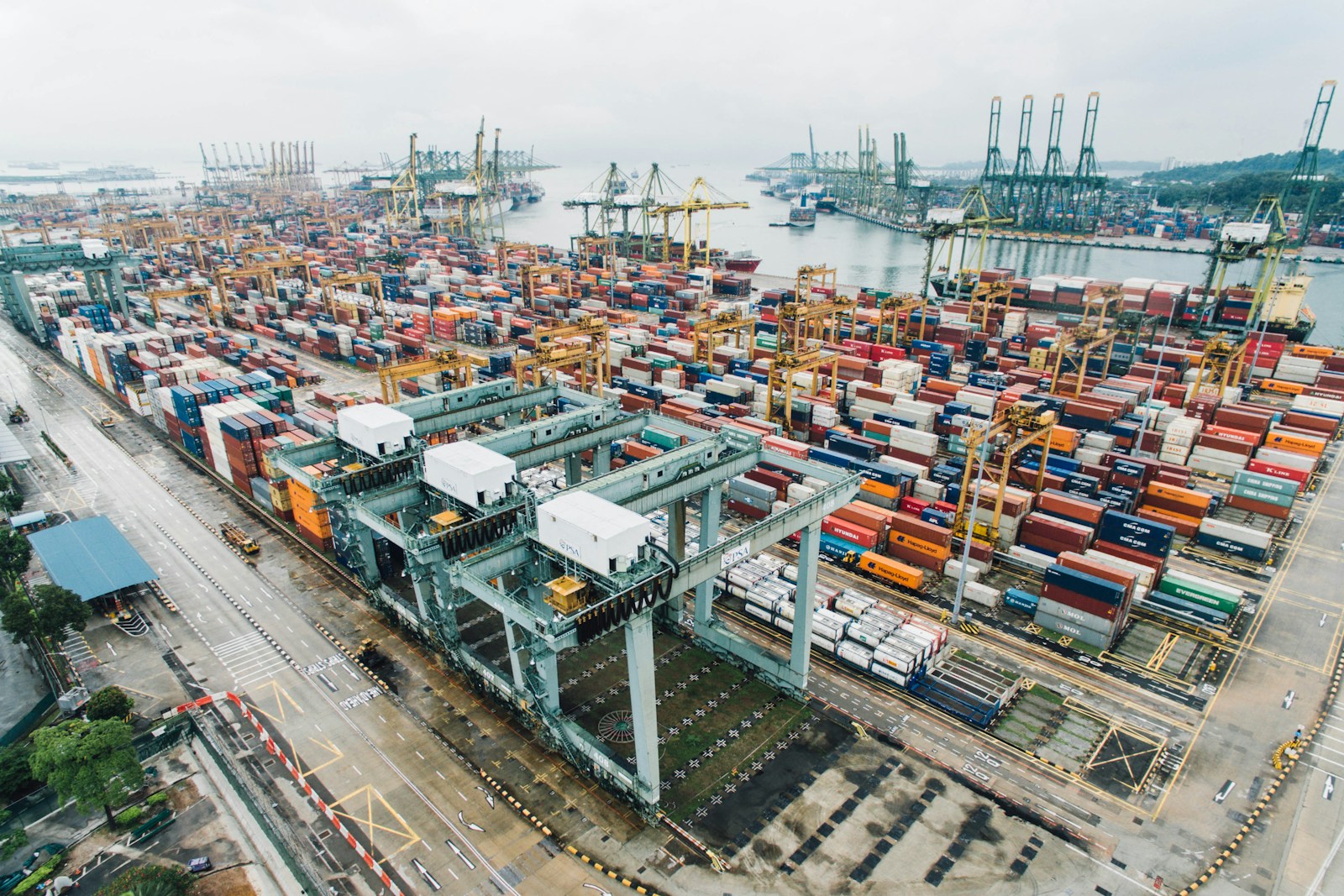 Aerial view of a busy container port with cranes, stacked containers and trucks, illustrating global textile and apparel trade flows
